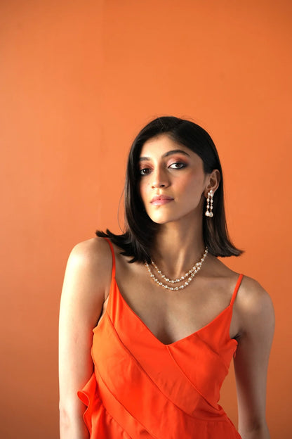 Sophisticated beauty shot showcasing a woman wearing statement chandelier earrings and stacked diamond necklaces.
