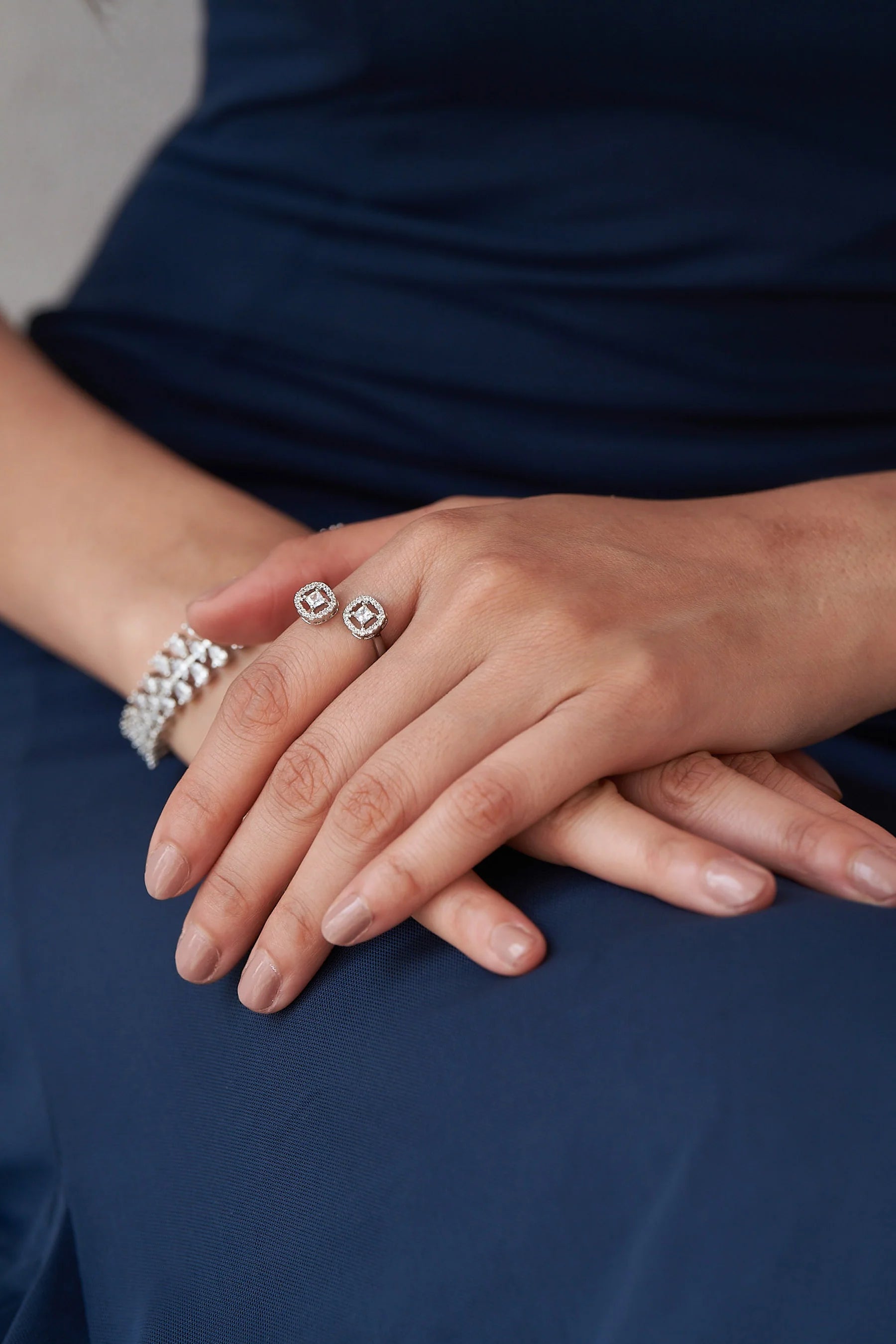 Elegant adjustable-style ring with dual diamond faces, combining structured square centers and soft rounded halos for a contemporary look.
