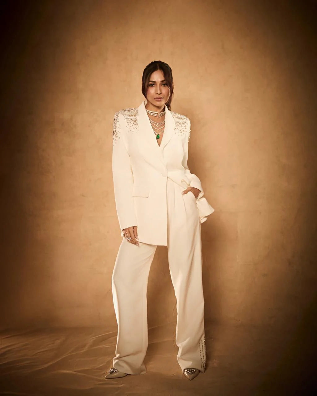 High fashion look featuring cream blazer with crystal embellishments and layered necklace styling
