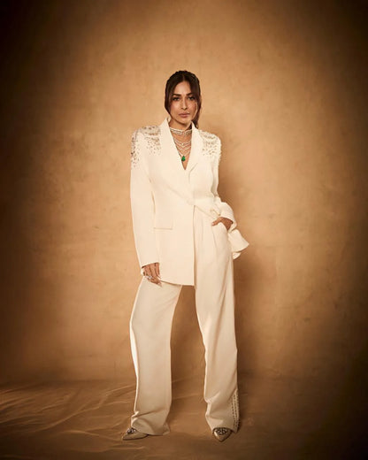 High fashion look featuring cream blazer with crystal embellishments and layered necklace styling
