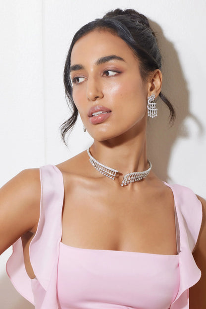 Fashion model wearing ivory blazer and statement jewelry set with gold and emerald accents
