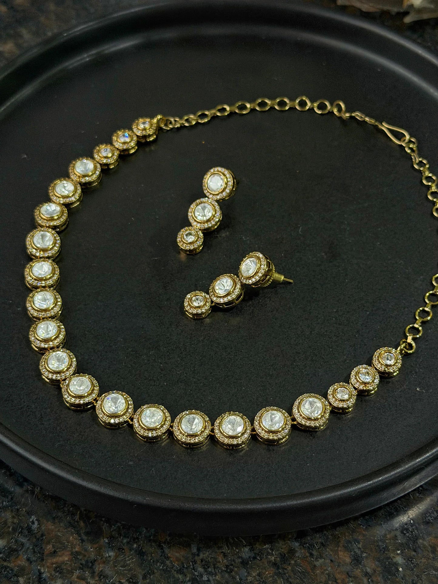 Premium gold necklace with round gemstone links and coordinated drop earrings display
