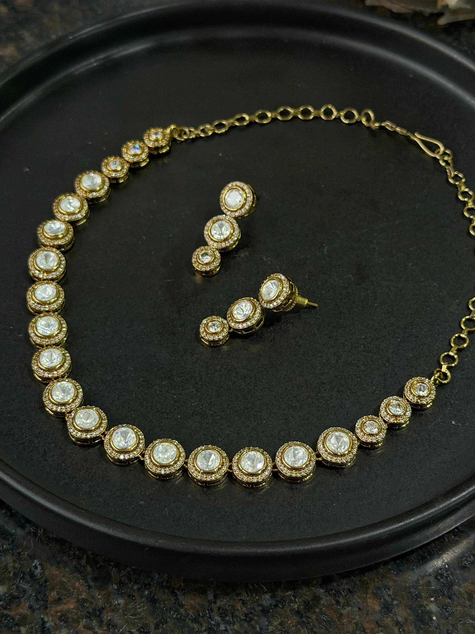 Premium gold necklace with round gemstone links and coordinated drop earrings display
