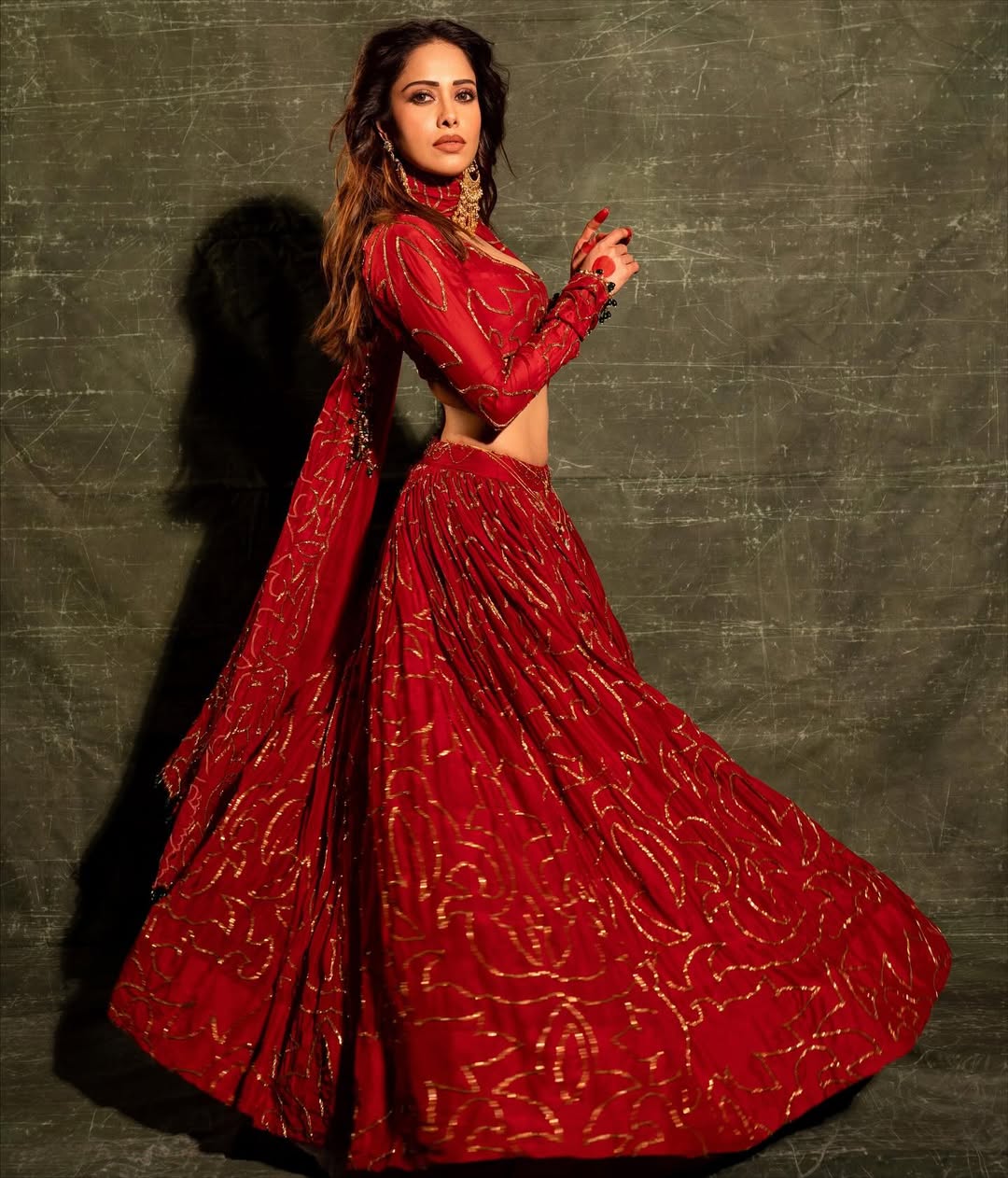 Elegant red lehenga choli with intricate embroidery and statement earrings
