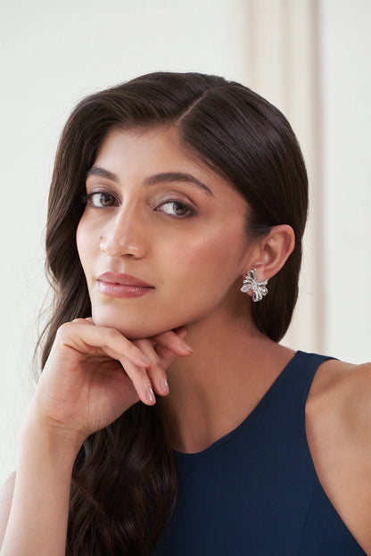 Sterling silver bow earrings with pavé stone detailing and sculpted ribbon design for festive and party wear