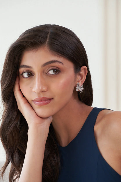 Sterling silver bow earrings with pavé stone detailing and sculpted ribbon design for festive and party wear