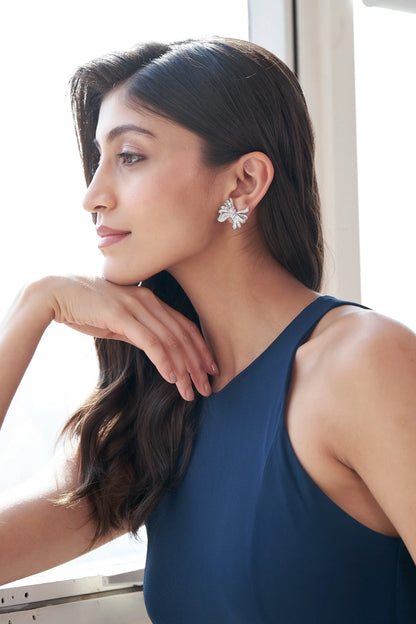 Sterling silver bow earrings with pavé stone detailing and sculpted ribbon design for festive and party wear