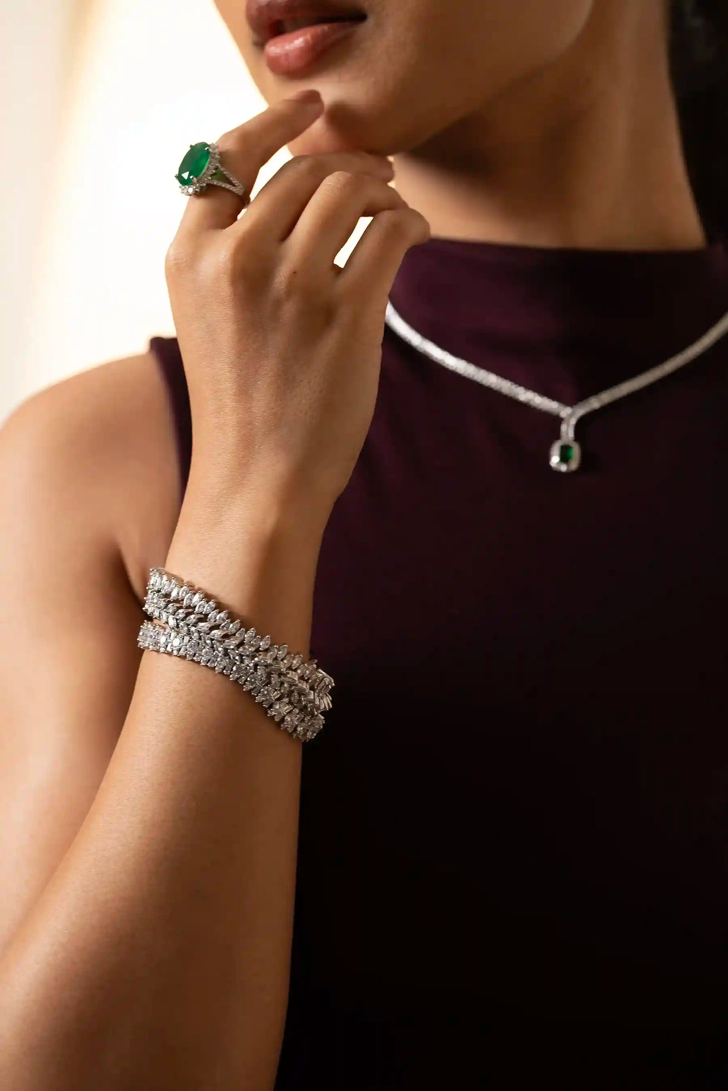 Detailed view of emerald ring with oval green gemstone and diamond halo setting in elegant fine jewelry design