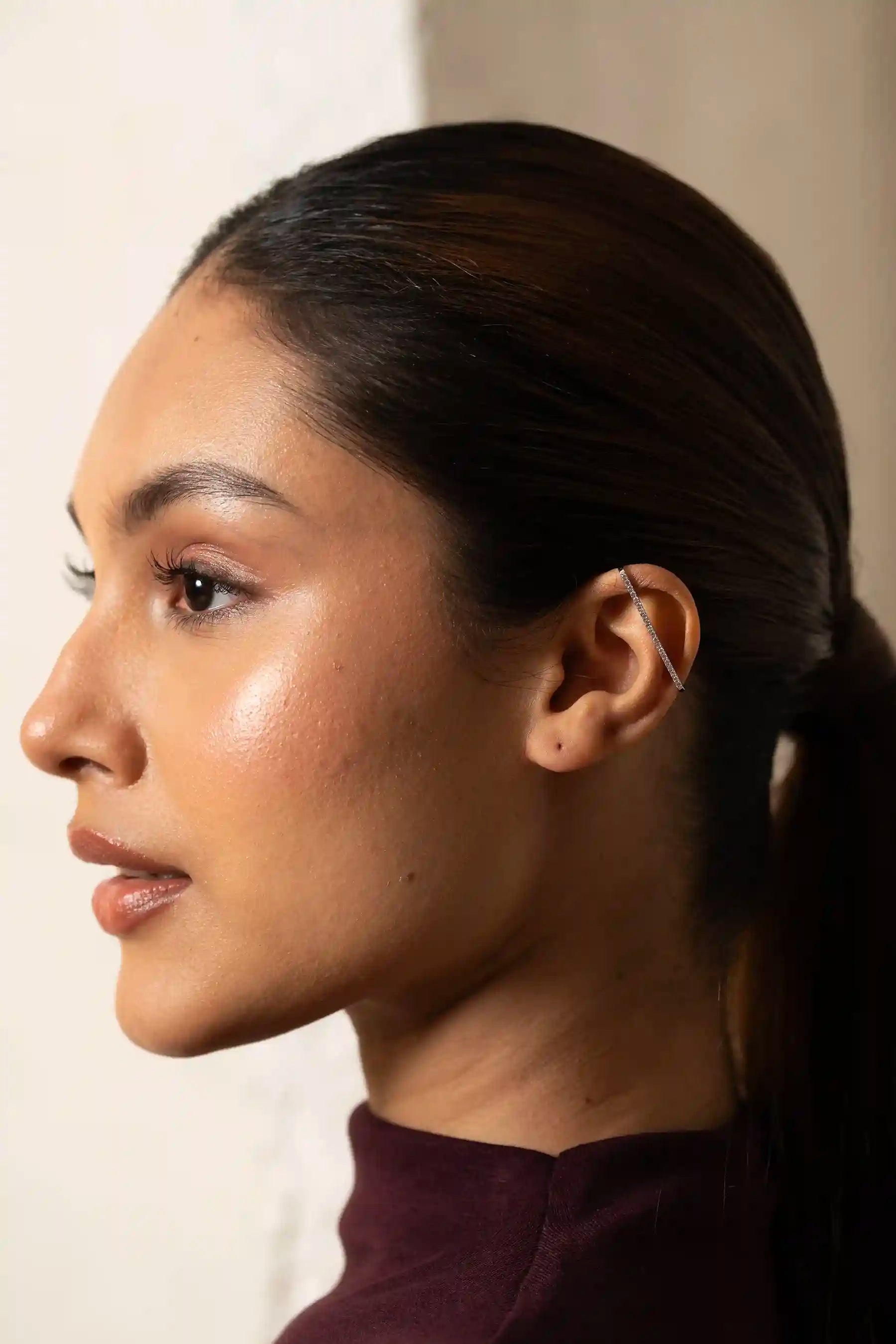 Macro shot of a crystal-lined ear cuff on a person’s ear, highlighting elegant and trendy fashion accessories