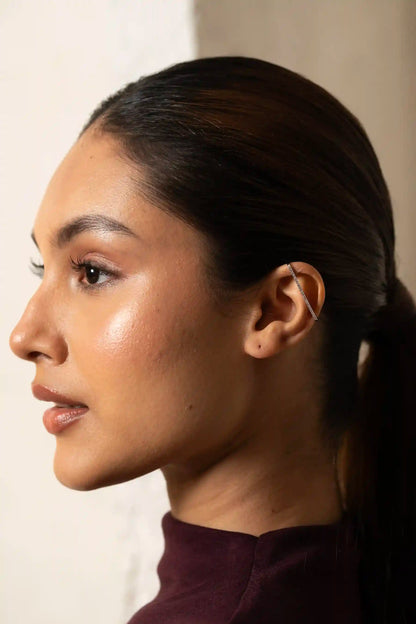Macro shot of a crystal-lined ear cuff on a person’s ear, highlighting elegant and trendy fashion accessories