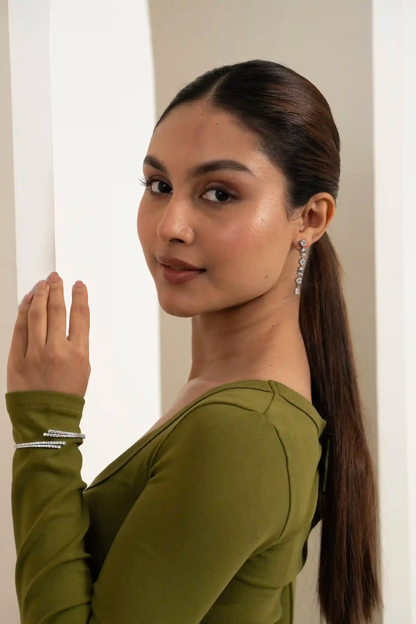 Elegant female model showcasing sparkling drop earrings with a sleek hairstyle, modern jewelry fashion photography