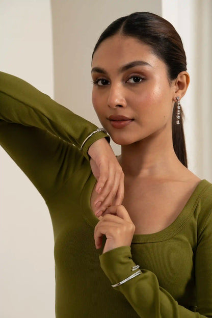High-resolution portrait of a woman wearing diamond drop earrings and green outfit, elegant jewelry styling