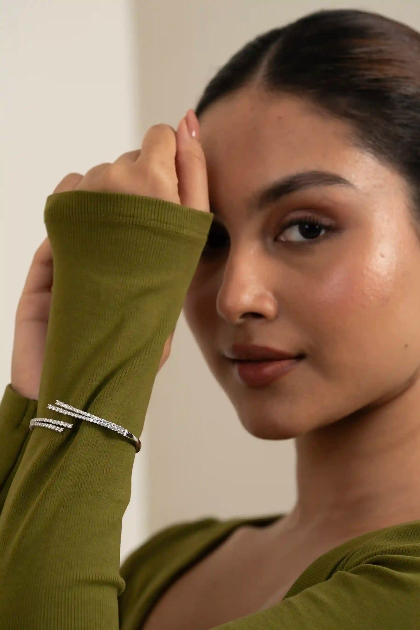 Beauty portrait of a woman showcasing sparkling drop earrings and minimalist bracelets, trendy fashion accessories