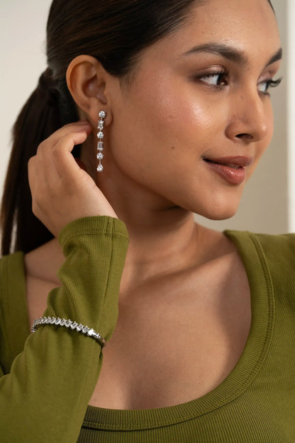 Woman wearing a sleek diamond bracelet with emerald-cut stones, elegant and trendy fashion accessory