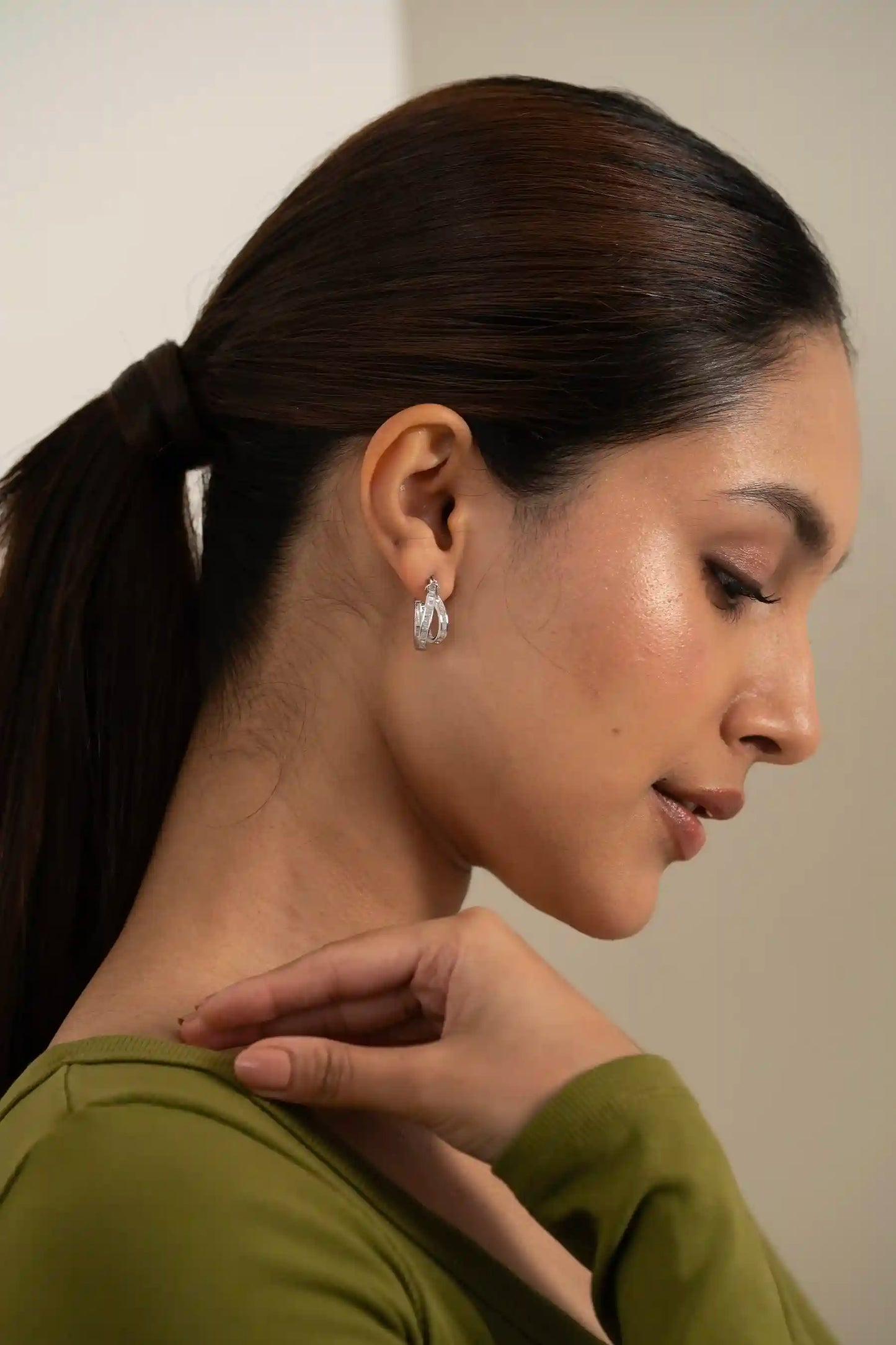Elegant diamond hoop earring with channel-set baguette stones, close-up fashion jewelry detail