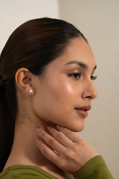 Elegant emerald cut diamond stud on ear, timeless women’s jewelry style close-up
