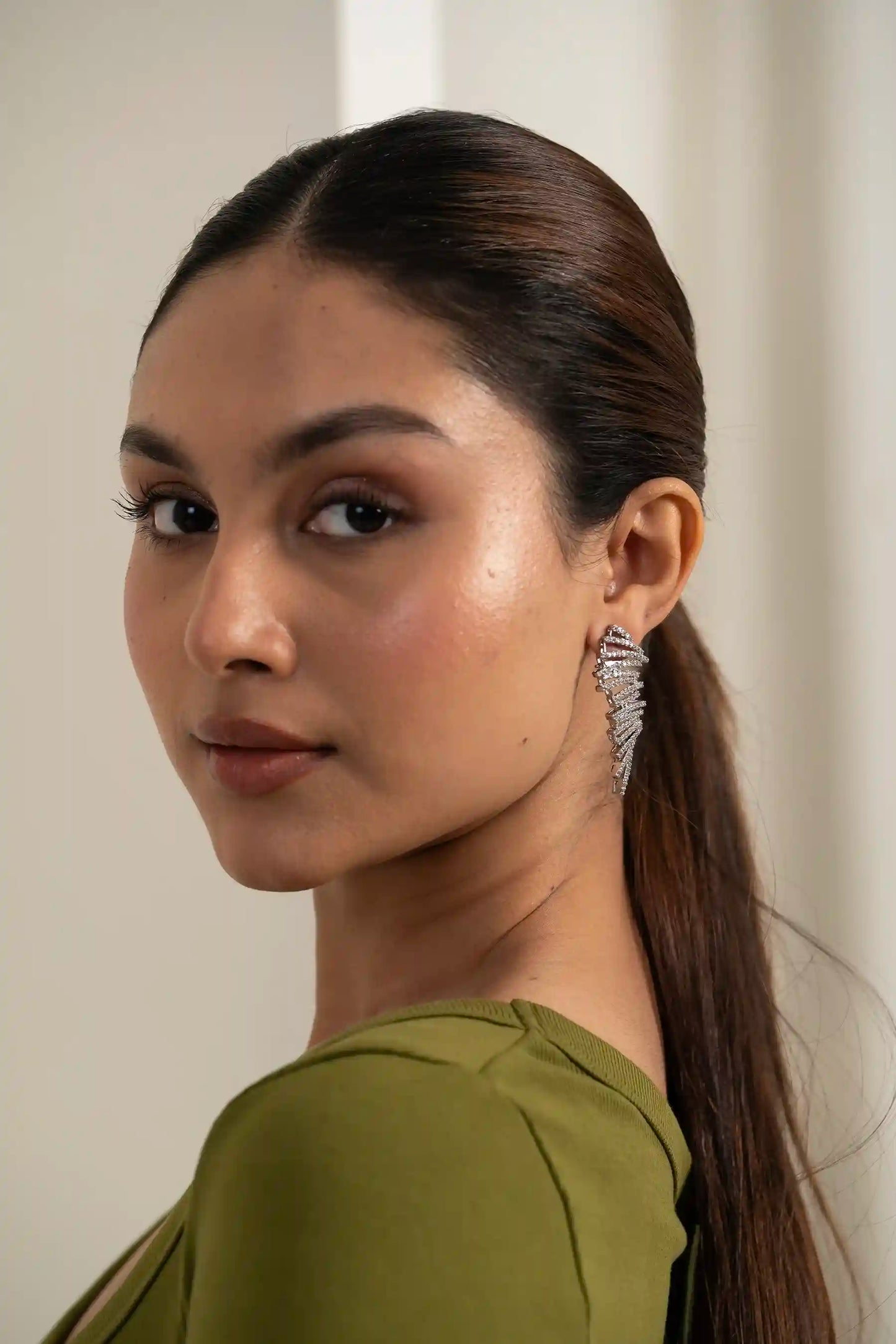 Diamond ear sweep earring shaped like a feather, delicate handcrafted design grazing the jawline