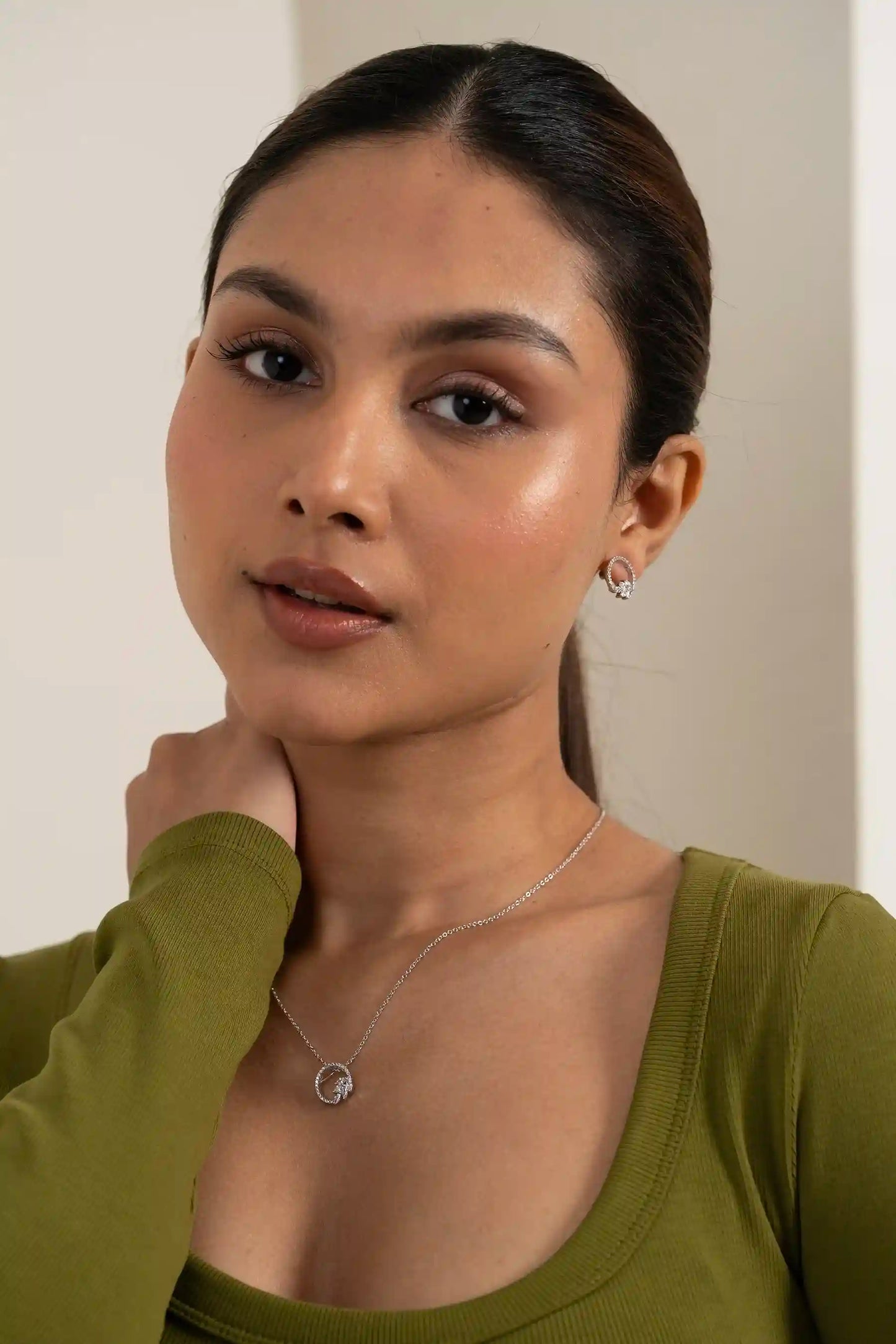 Side profile of model wearing open circle diamond pendant and matching stud earrings with minimal styling