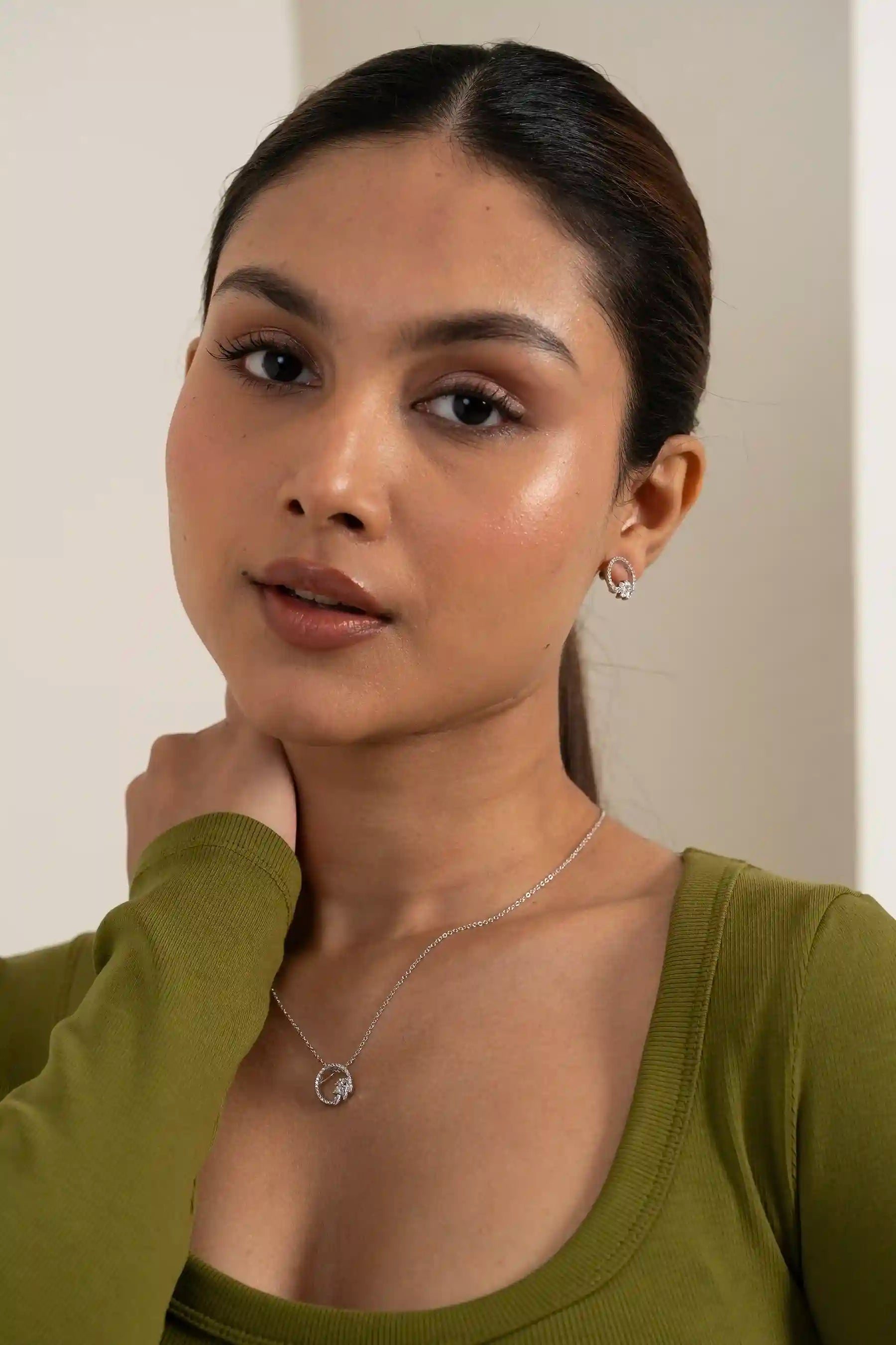 Side profile of model wearing open circle diamond pendant and matching stud earrings with minimal styling