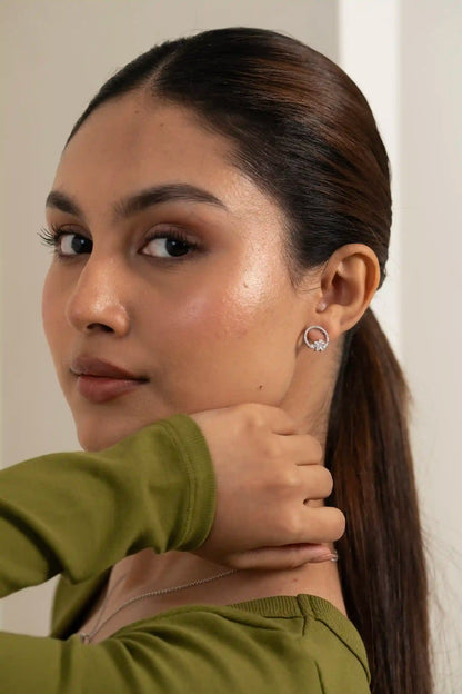 Open circle diamond pendant set styled on model with soft glow skin and clean editorial look