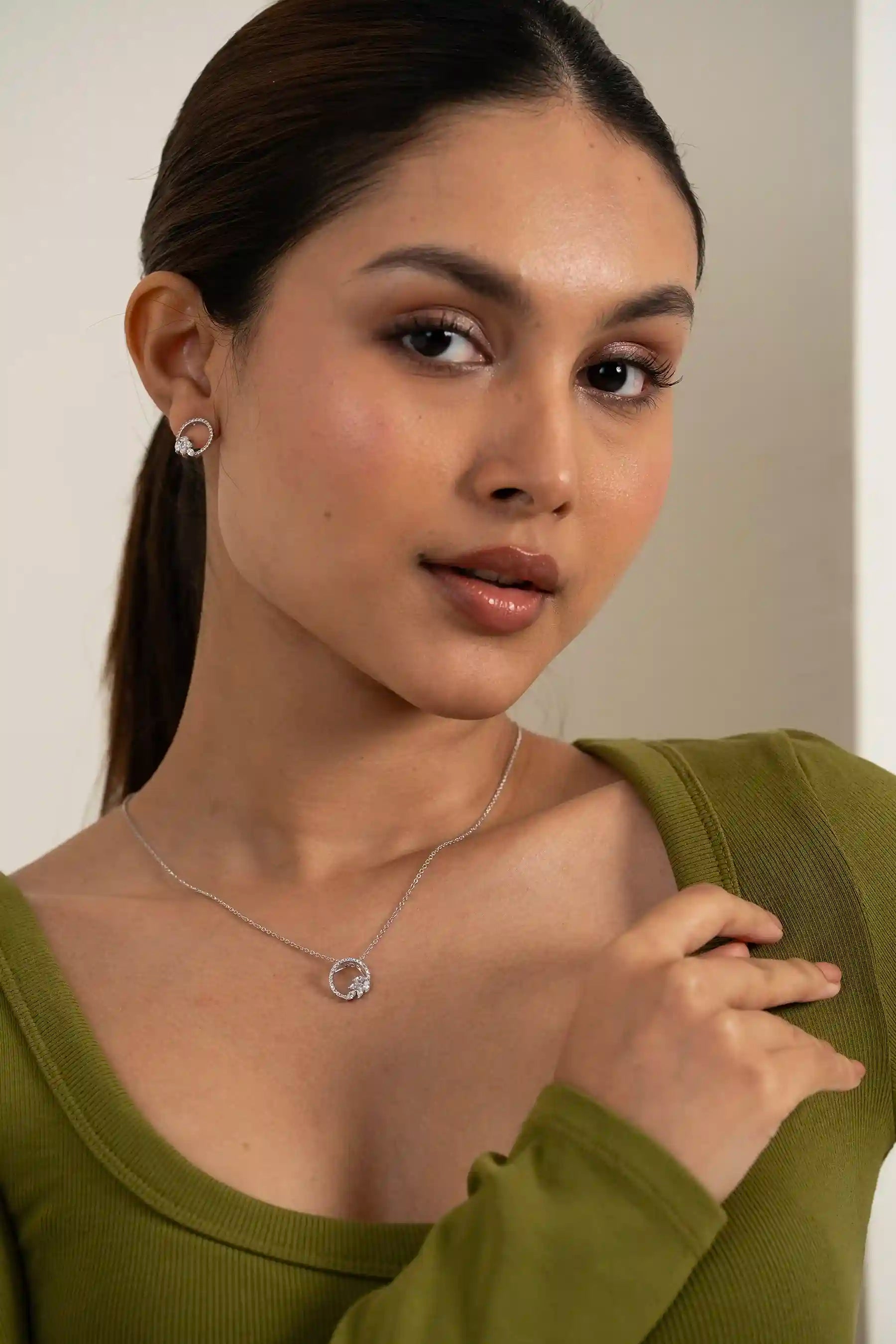 Modern diamond circle pendant and stud earrings styled on model with clean, premium finish
