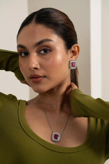 Cushion-cut ruby necklace set with diamond halo earrings styled for occasion wear with natural candid expression