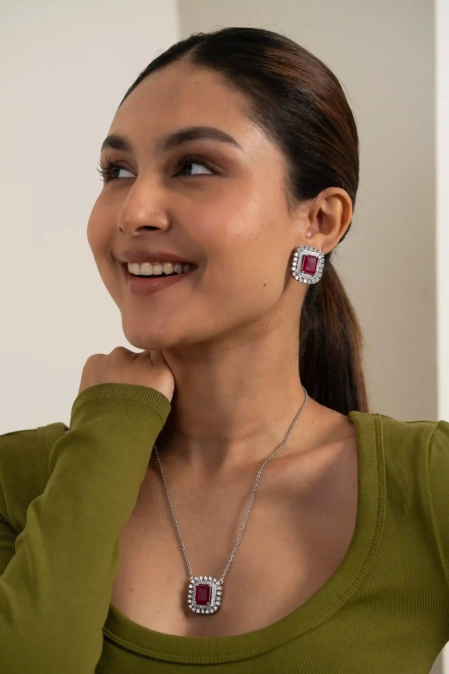 Close-up of ruby cushion halo earring with double diamond frame detailing and rich red center stone
