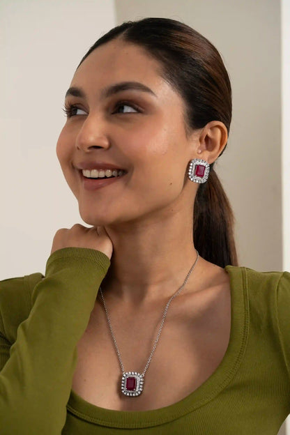 Close-up of ruby cushion halo earring with double diamond frame detailing and rich red center stone