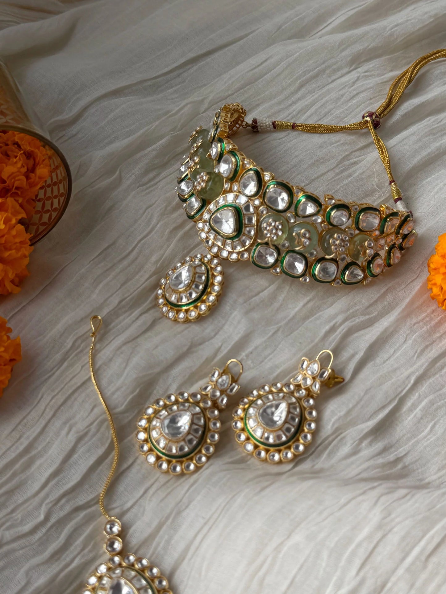 High-end bridal jewelry featuring kundan choker with intricate stonework and drop pendant
