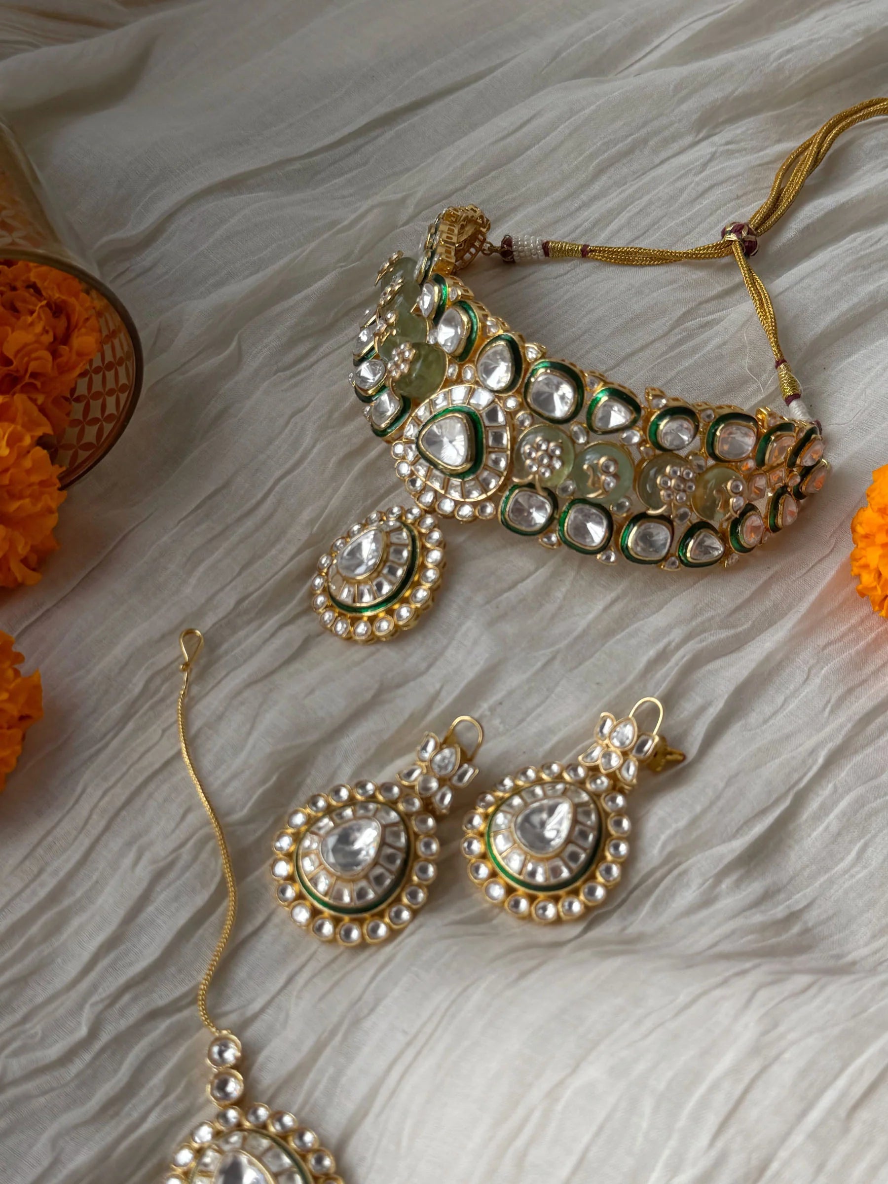 High-end bridal jewelry featuring kundan choker with intricate stonework and drop pendant
