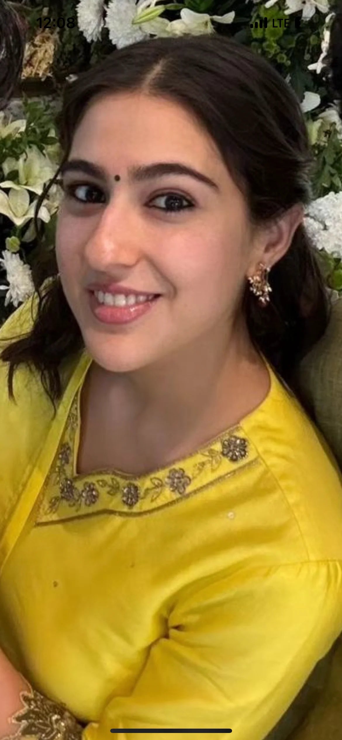 Beauty portrait highlighting a woman’s radiant expression, featuring minimal gold earrings and a traditional bindi detail.
