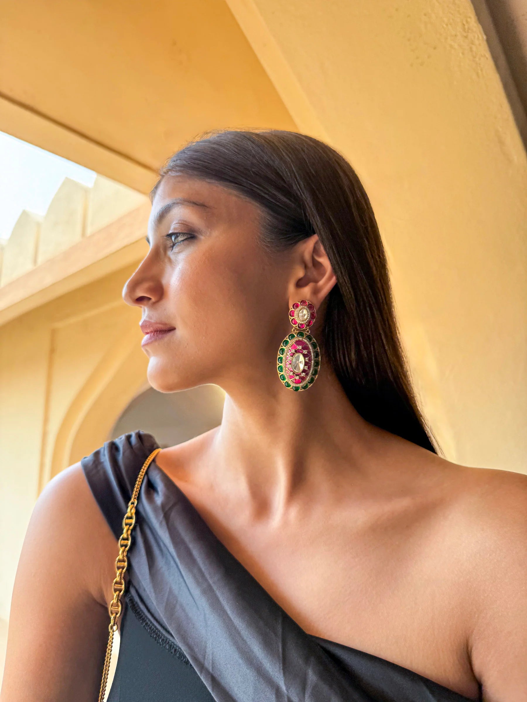 Editorial-style portrait of a woman in a gold embroidered ensemble with elegant jewelry

