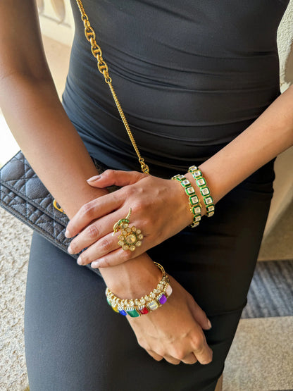 Indoor fashion shoot featuring a woman in a richly textured gold outfit with statement jewelry
