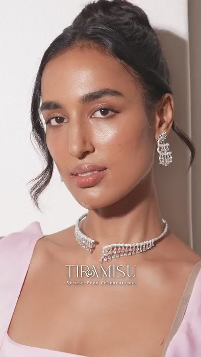 Glamorous model in ivory blazer paired with diamond choker and emerald pendant necklace
